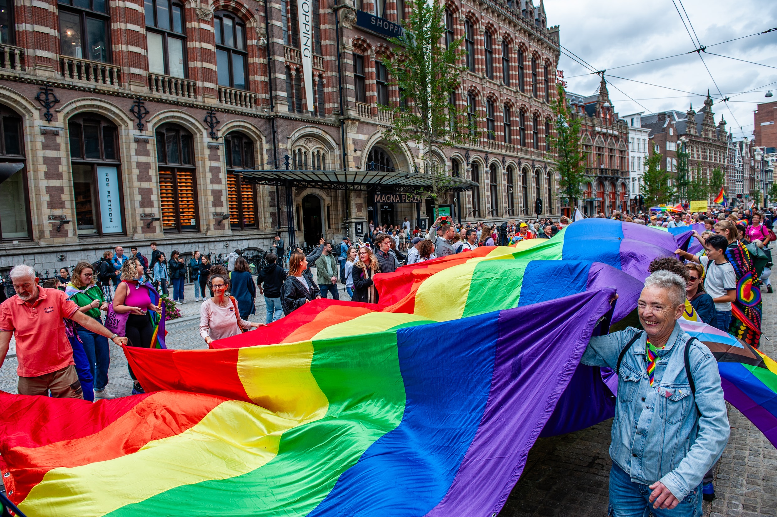 Deelnemers Pride Walk lopen route door Amsterdam | Het Parool