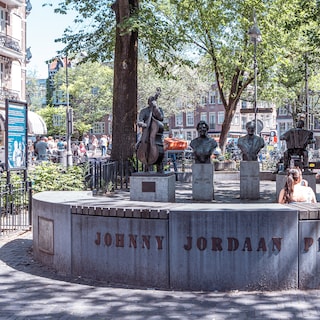 Johnny Jordaan is the centerpiece in this collection of folk singer statues near the old Wester church