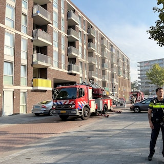 Apartment building evacuated after fire in Noord, residents on the sidewalk in pajamas