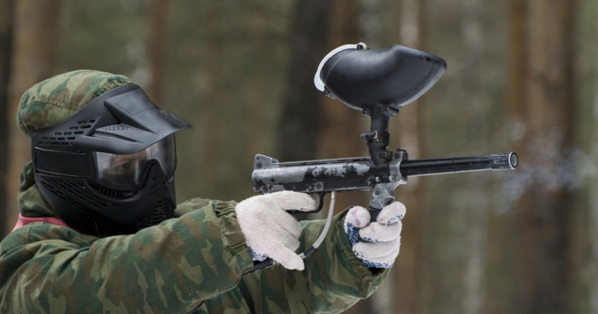Paintbalspeler in Beschermende Kleding En Masker Die Buiten Speelt En Schiet Met Een Wapen